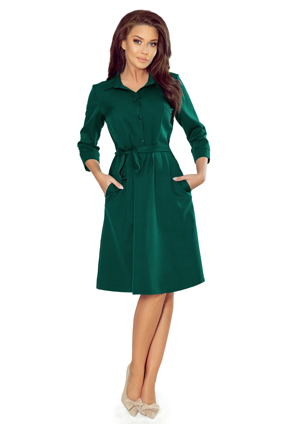 A stylish green dress with a classic collar and button-down front, featuring a waist tie for a flattering silhouette. The dress has long sleeves and convenient side pockets, perfect for a chic and comfortable look.