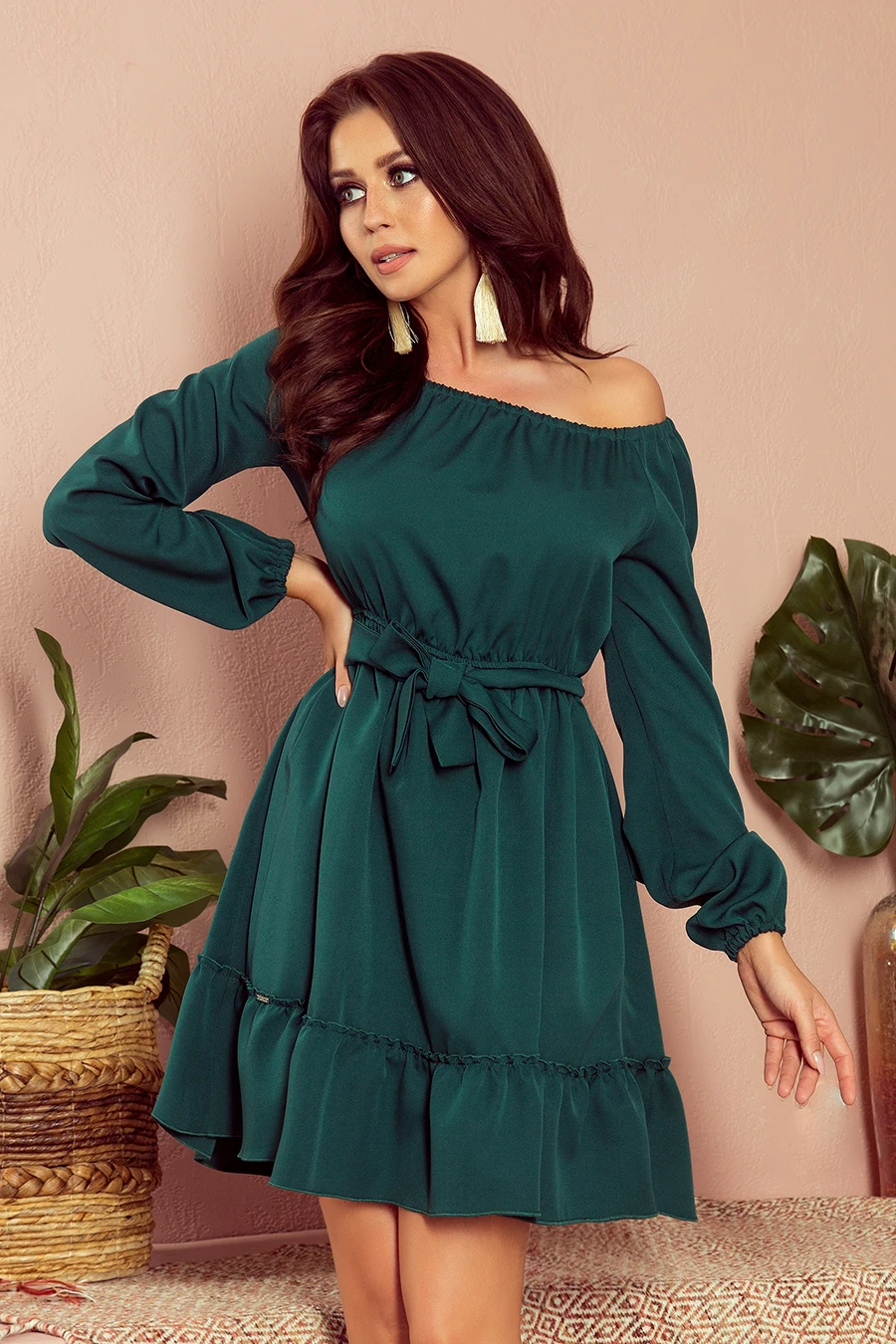 A stylish off-the-shoulder green dress with long sleeves and a waist tie, perfect for a chic and elegant look. The dress features a ruffled hem, adding a touch of femininity and flair.