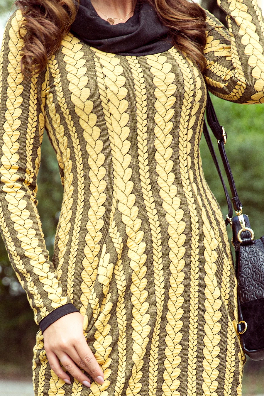 A stylish dress featuring a bold yellow leaf pattern on a dark background, complemented by a black collar. The design is both eye-catching and elegant, perfect for making a statement.