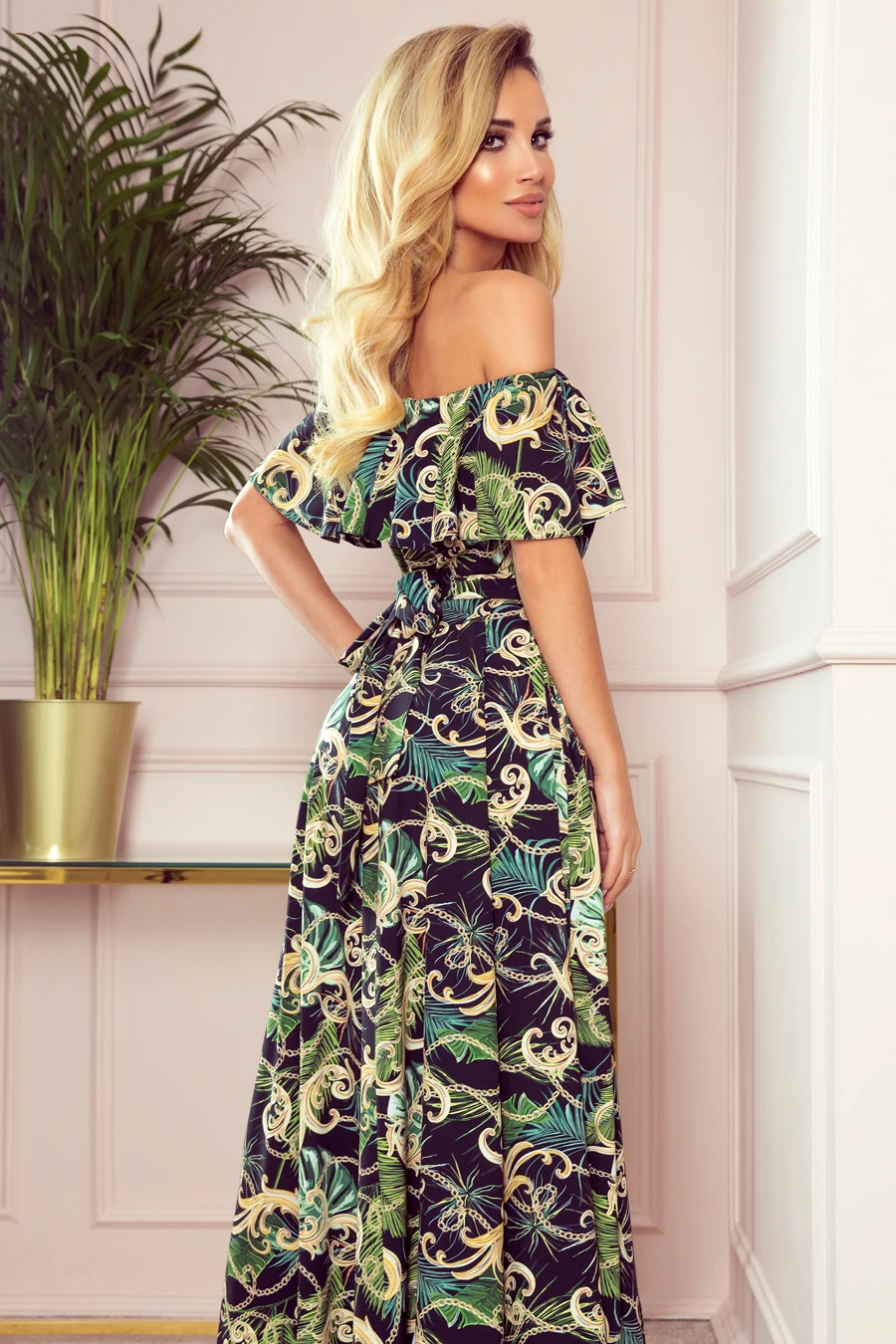 The image features a stylish off-the-shoulder maxi dress with a vibrant green and gold pattern, perfect for a summer occasion. The dress is complemented by a flowing silhouette and intricate design details.