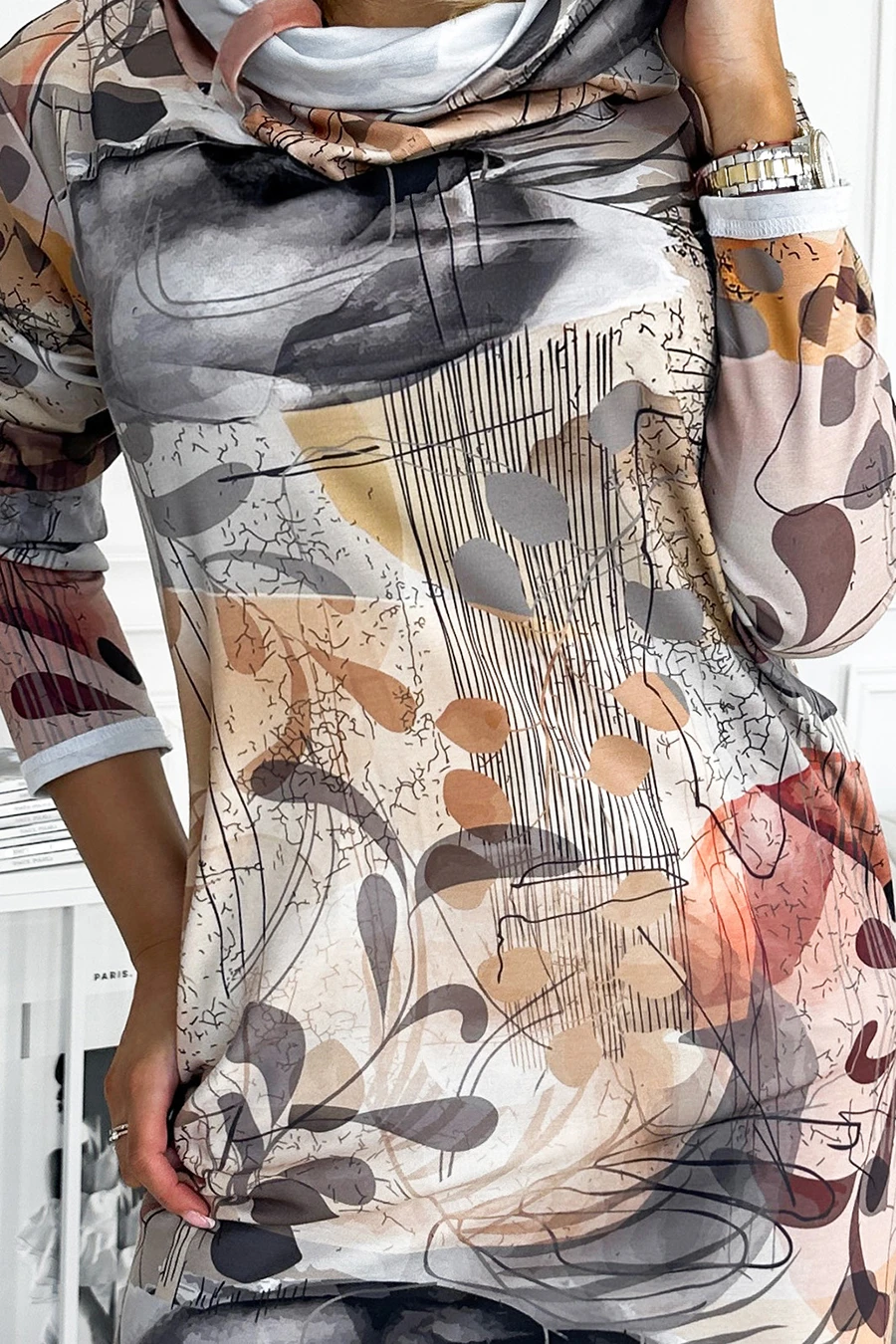 A stylish dress featuring an abstract floral pattern in earthy tones, perfect for a modern and artistic look. The design includes a comfortable fit with three-quarter sleeves and a subtle cowl neckline.