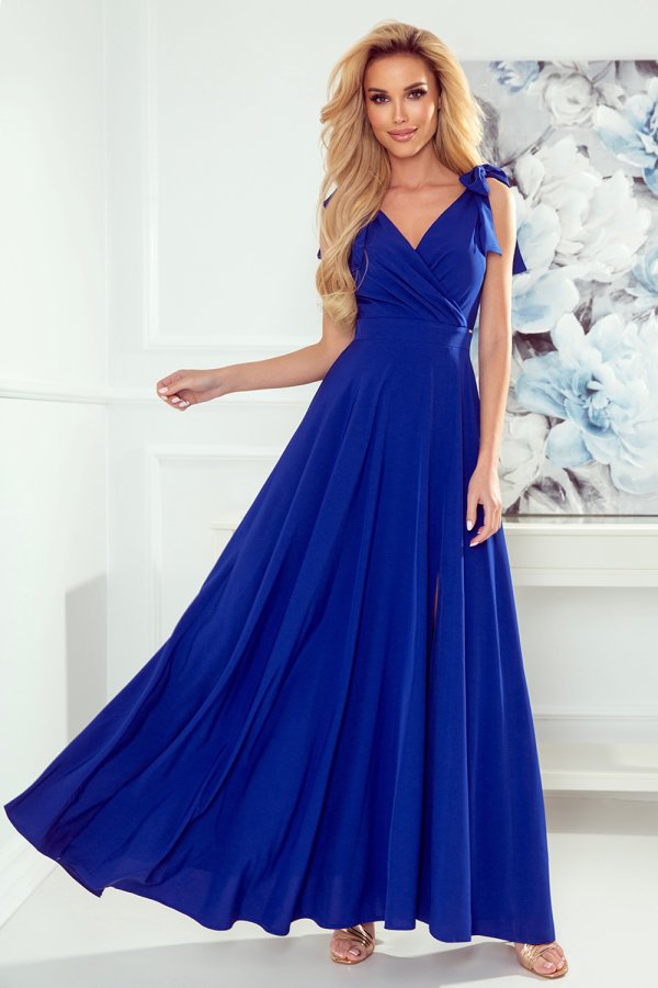 A stunning royal blue evening gown with a flowing skirt and elegant shoulder ties. The dress features a flattering V-neckline and a subtle slit for added sophistication.