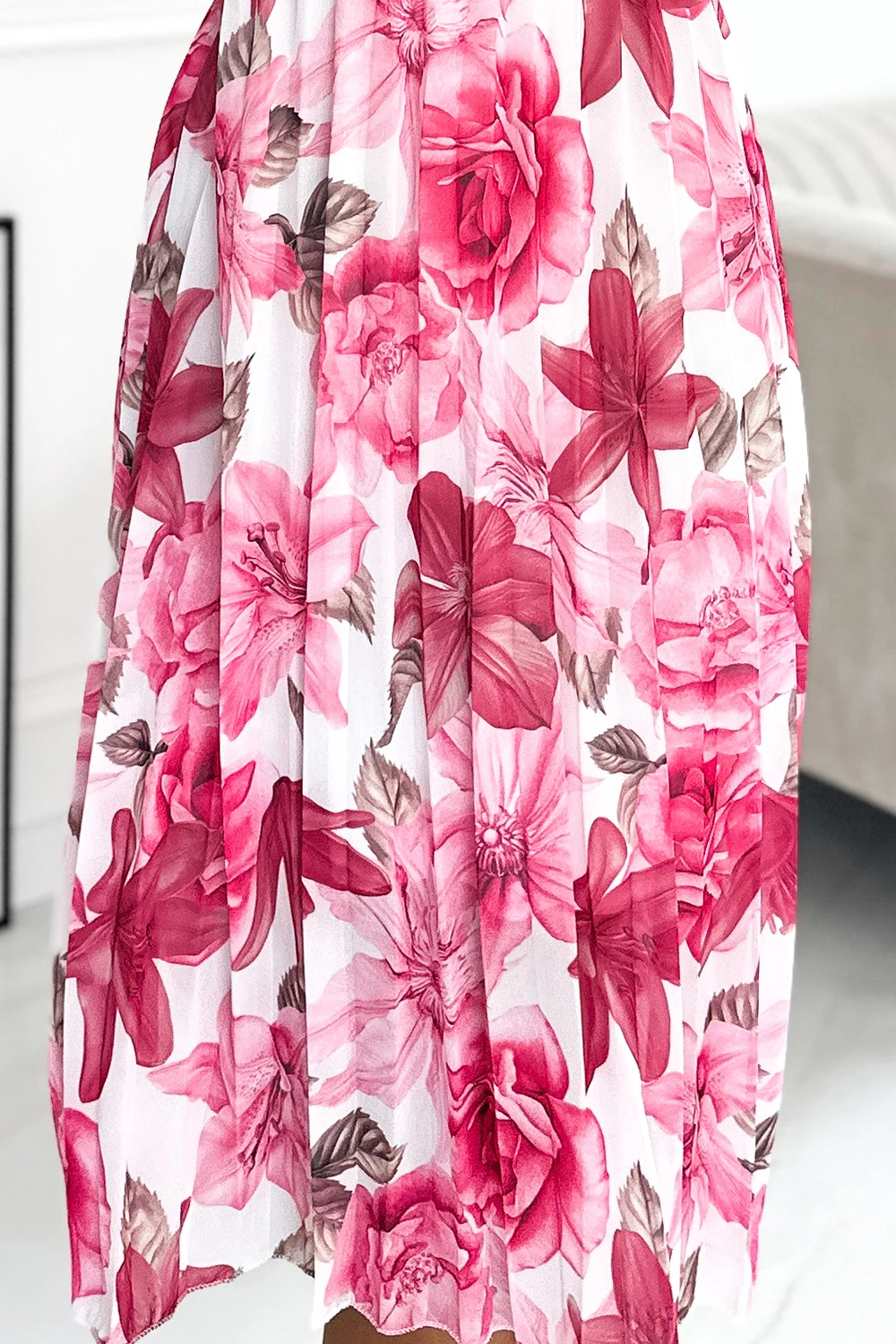 A flowing skirt adorned with vibrant pink and red floral patterns creates a lively and elegant look. The lightweight fabric enhances the skirt\'s graceful movement, perfect for a stylish and feminine outfit.