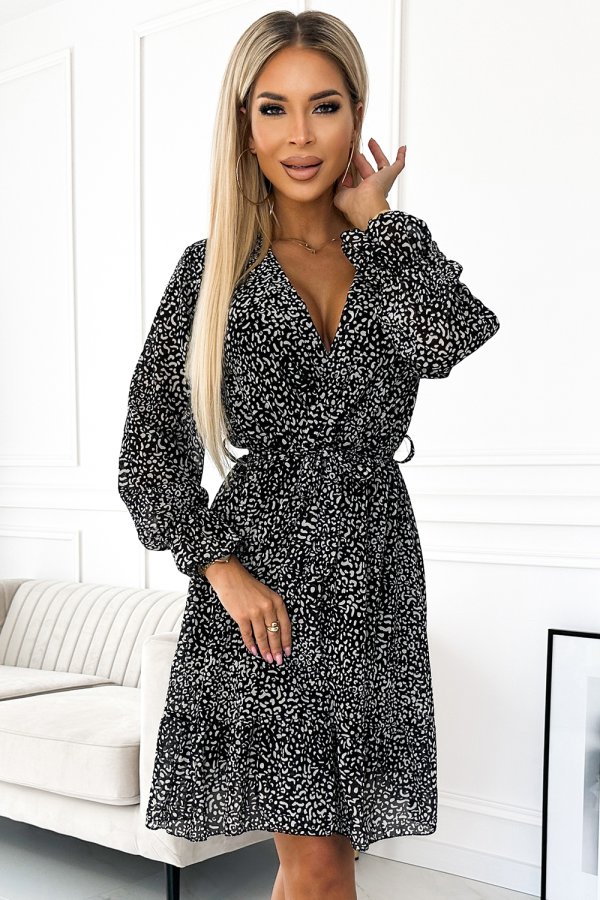 The image features a stylish black and white patterned dress with long sleeves and a flattering V-neckline. The dress is cinched at the waist, creating an elegant and feminine silhouette.