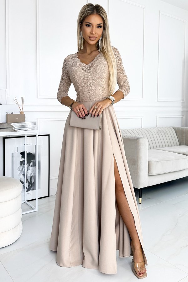 Elegant long beige dress with lace detailing on the bodice and a high slit on the skirt. The dress is complemented by a matching clutch, creating a sophisticated and stylish look.