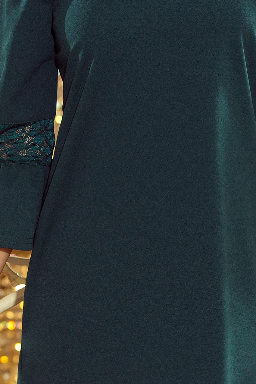 A dark green dress features elegant lace detailing on the sleeves, adding a touch of sophistication. The fabric drapes smoothly, offering a refined and stylish appearance.