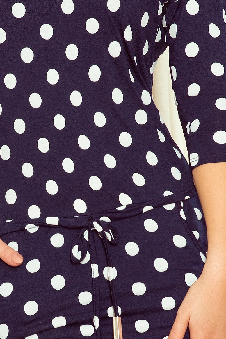 The image shows a navy blue garment with a white polka dot pattern, featuring a drawstring at the waist. The fabric appears soft and comfortable, ideal for casual wear.