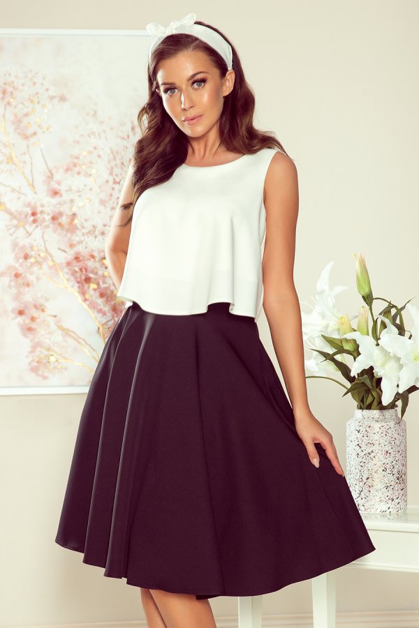 A stylish two-tone dress featuring a white sleeveless top and a flowing black skirt. The elegant design is perfect for both casual and formal occasions.