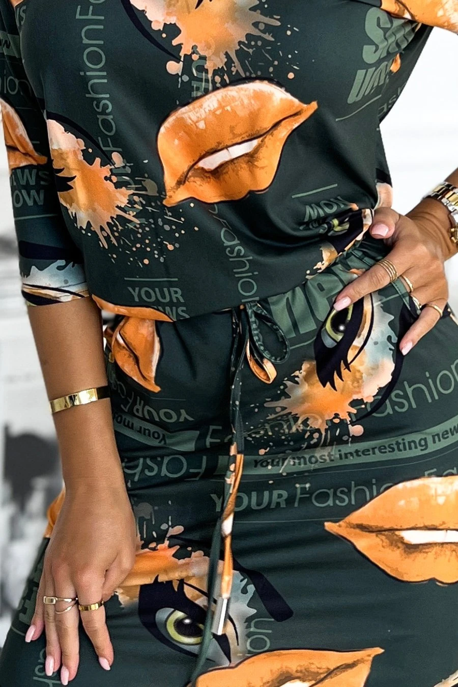 The woman in the photo is wearing a stunning green cocktail dress, featuring elegant ruffle detailing at the neckline. This chic cocktail dress perfectly complements her sophisticated style, ideal for any special occasion.