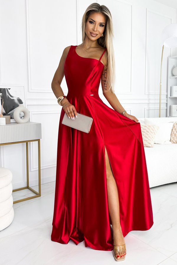 A stunning red evening gown with a sleek, floor-length design and a stylish side slit. The dress is complemented by a simple, elegant clutch, perfect for formal occasions.