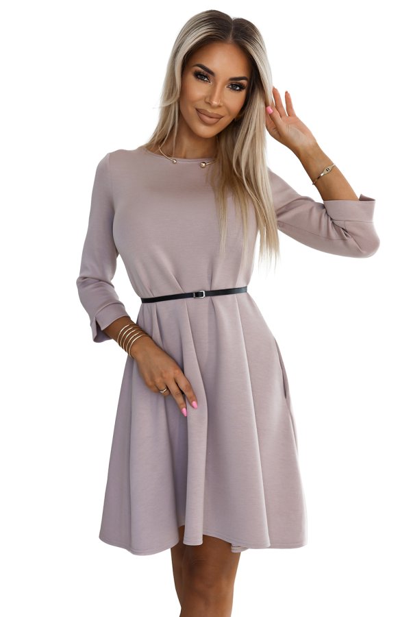 The image features a stylish, knee-length, light mauve dress with long sleeves and a black belt accentuating the waist. The dress has a simple yet elegant design, perfect for both casual and formal occasions.
